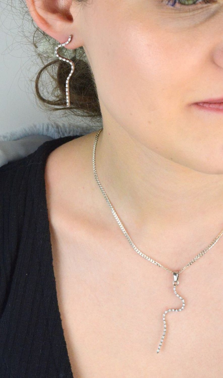 Zawieszka damska W 1580 wykonana ze srebra próby 925. Długość 5,5 cm, zdobiona drobną cyrkonią o szerokości 1 mm, waga 1,91 g. Smukła, elegancka biżuteria na każdą okazję.1.jpg